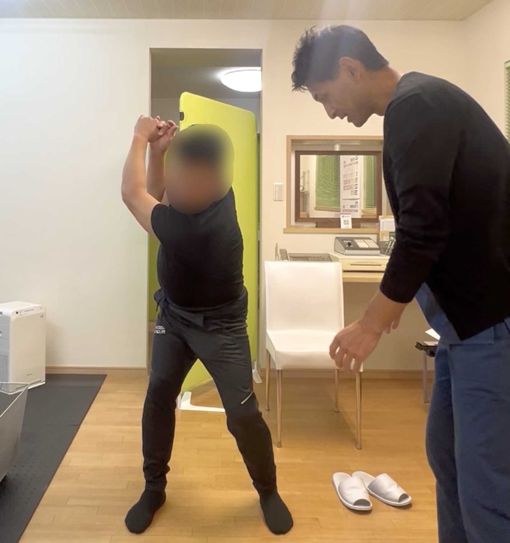 Kさんがゴルフのスイング動作を行い、施術者がそのフォームを観察・修正しているシーン。